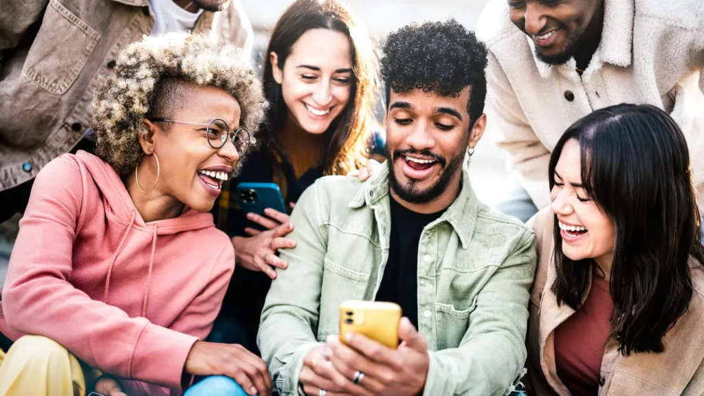 A Group Of People Looking At A Phone